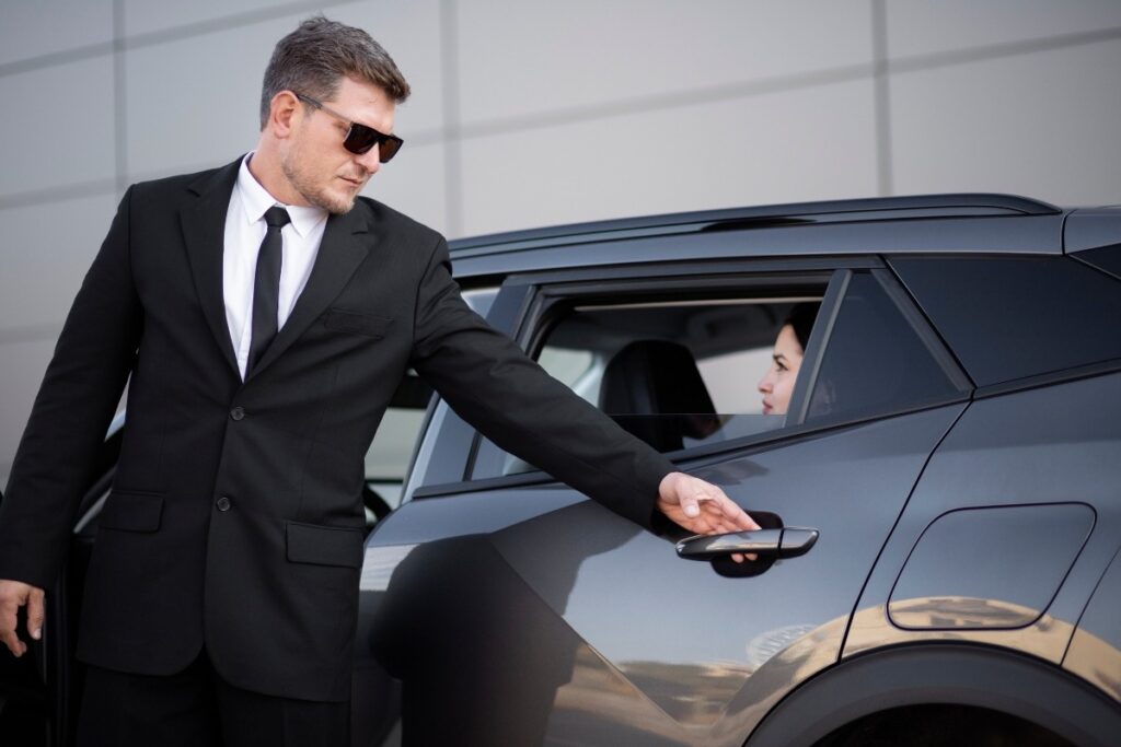 A professional chauffeur opening a door for a client.